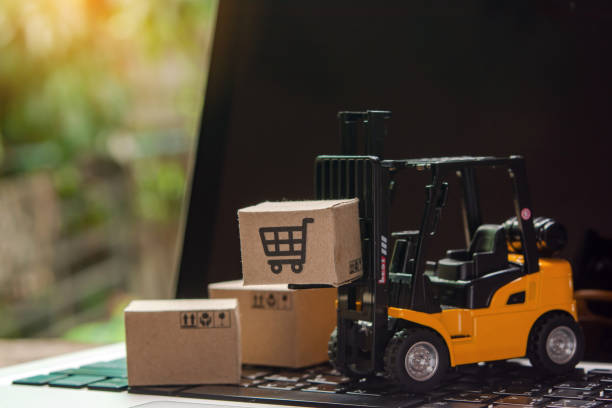 istock Forklift loader a pallet with Paper cartons or parcel on laptop 1447183745
