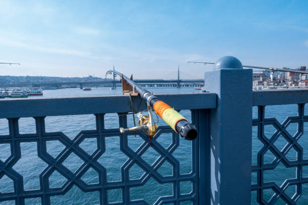 una caña de pescar aislada y una línea de pesca en un puente y paisaje marino en estambul - turkish culture turkey fishing boat fishing fotografías e imágenes de stock