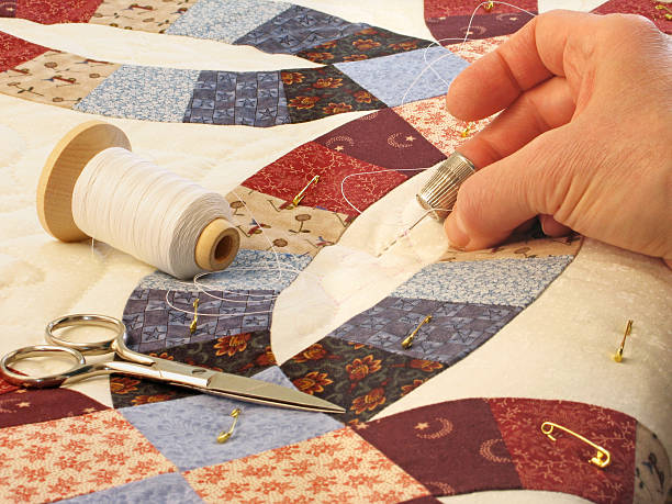 Hand quilting of double wedding ring patterned quilt Hand quilting heart-shaped pattern on double wedding ring patterned quilt Amish stock pictures, royalty-free photos & images