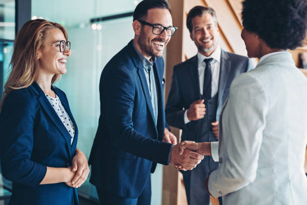 Empresário e empresária cumprimentando-se em uma reunião - foto de acervo