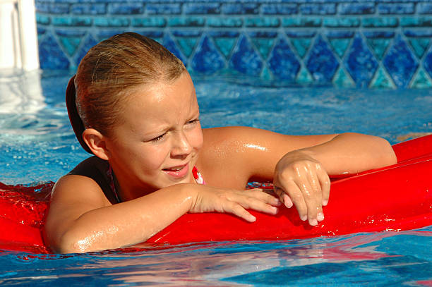 jeune fille sur floatie dans la piscine - inflatable ring water wings swimming pool float photos et images de collection