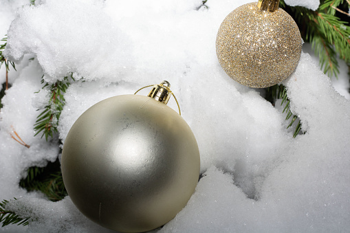 photo of a round-shaped toy on a branch in the snow in the woods