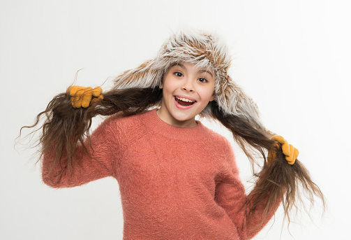 not spoiling your woolly sweater. cold winter weather. warm clothes and accessory fashion for kid. happy childhood. small girl in fur earflap hat and gloves. xmas holiday activity. child cosy sweater.