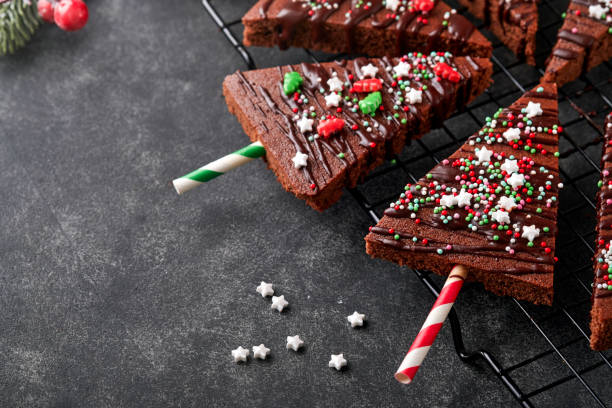 istock Chocolate brownies Christmas tree with chocolate icing and festive sprinkles on stone table. Christmas food ideas sweet homemade Christmas holidays pastry concept. Holiday cooking concept. Top view. 1447190319