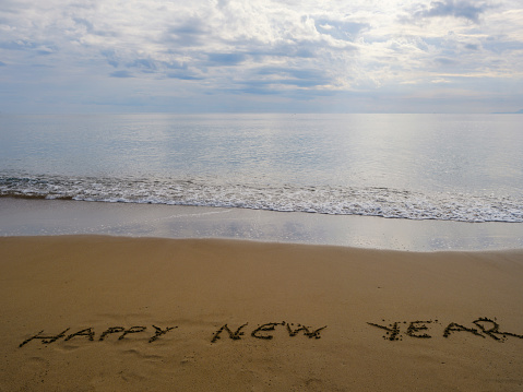 happy new year message on the sand beach