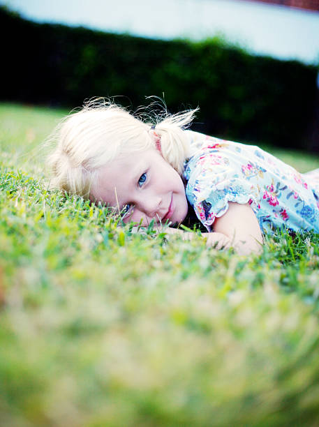 Summertime Young girl relaxing in the grass during the summer. hazel blue eyes stock pictures, royalty-free photos & images