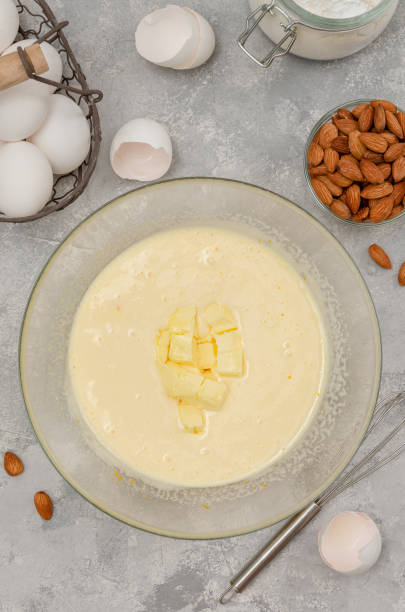istock Recipe step by step. The process of making Italian cantucini cookies. Whipped eggs with sugar and butter in a bowl on a gray concrete background. Top view. 1447195292