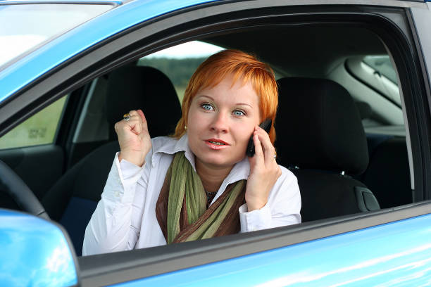 istock Red-haired woman with mobile-phone in a car 144719874