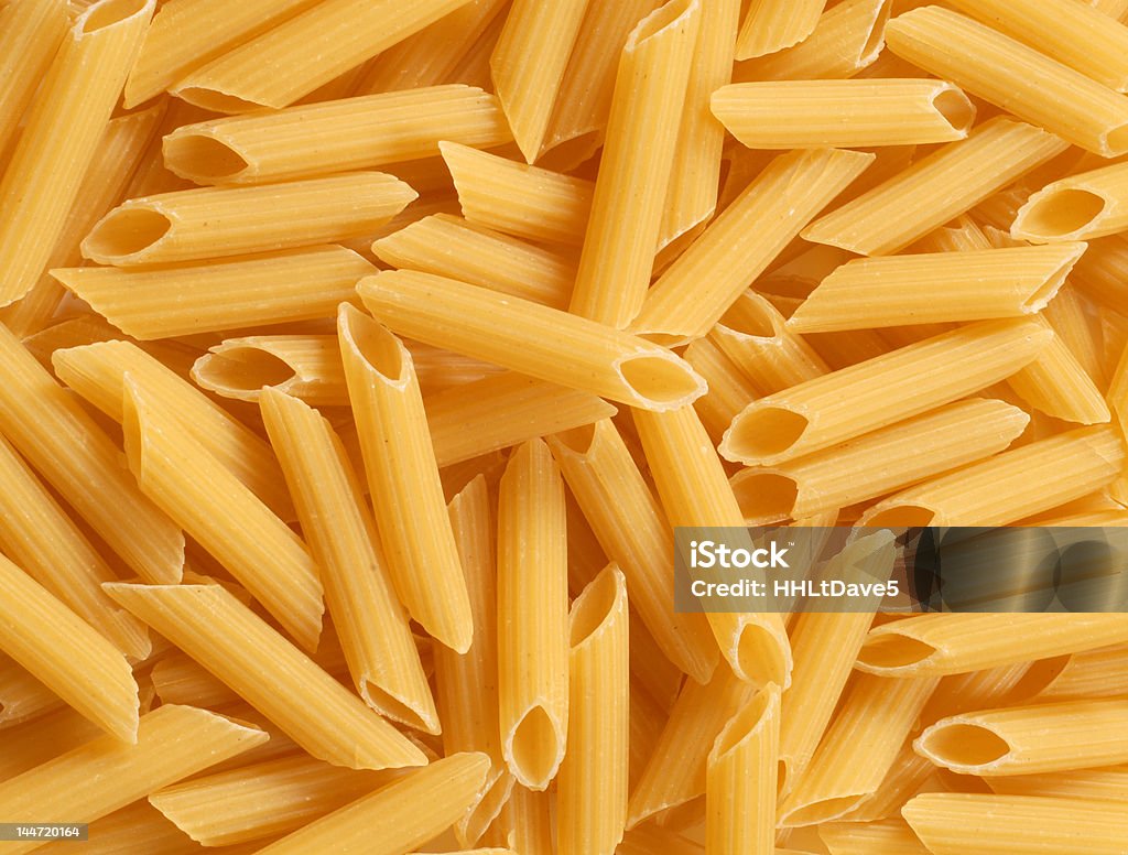 Background of fresh uncooked Penne pasta A background of delicious fresh uncooked Penne pasta Mostaccioli Stock Photo