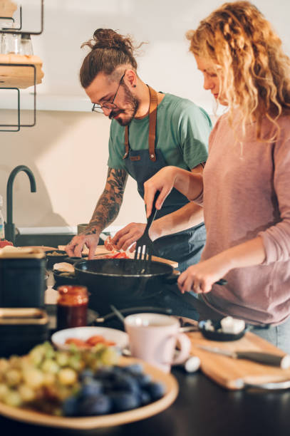 istock Young couple making breakfast together in the kitchen at home 1447203294