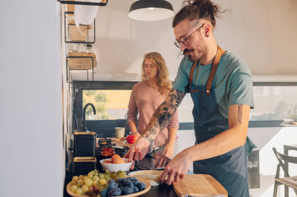 istock Young couple making breakfast together in the kitchen at home 1447203297