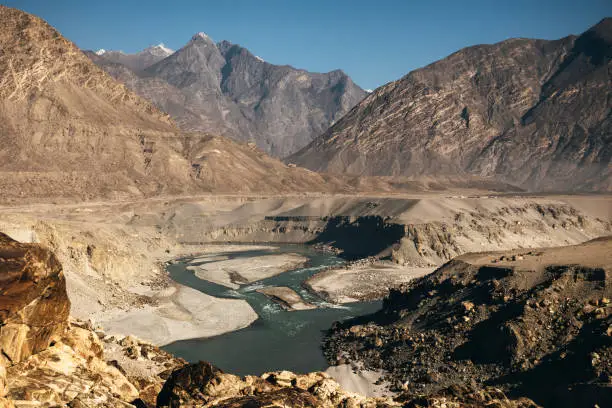 Flowing water of the Indus river in deep valley in the Karakoram mountains