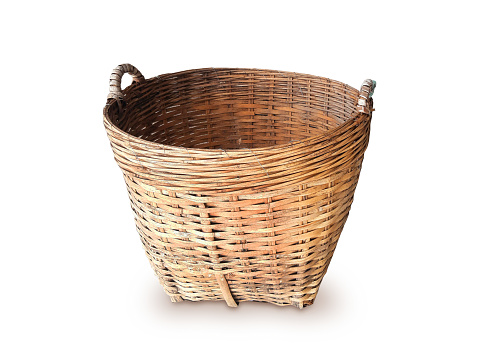 Front view of old oval wicker basket on white background. Close up of raffia basket. Storage and straw containers. Crafts and home equipment.