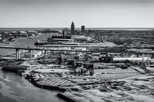 The industrial waterfront along the Mobile River with the downtown center of Mobile Alabama in the distance.