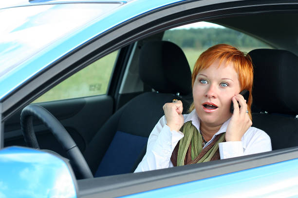 istock Red-haired woman with mobile-phone in a car 144720997