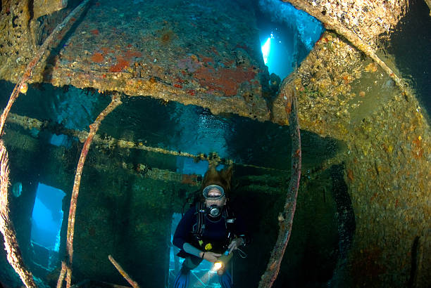 istock Woman diver exploring a war wreck 144721258