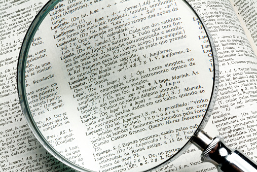 Magnifying glass over book text.
