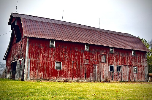 The big red barn in full length displaying signs of neglect and in need of a renovation