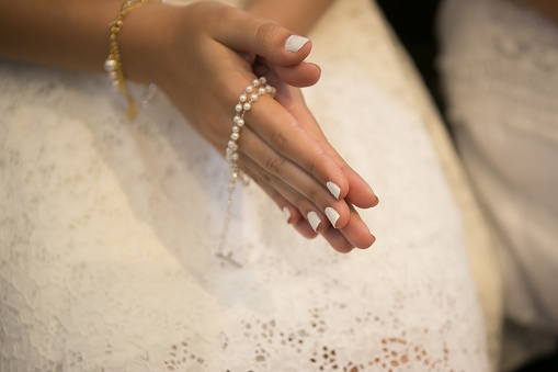 christian religion background with light bokeh christian woman hand on holy bible praying to god holding cross rosary selective focus at cross. concept of christian religious people faith and practise