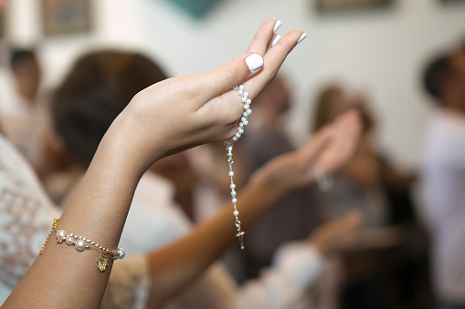 Child's hand holding rosary (Catholic)