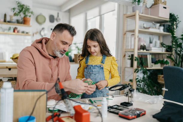 istock Father and daughter building robot 1447231260