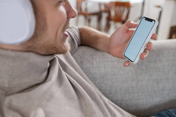 istock Man relaxing on the couch and using mobile phone 1447232095