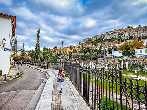 rearview of a young girl walking in down town Athens exploring the monuments by the Acropolis