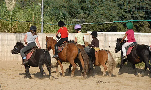 group of children horseback riding on their shetland ponies