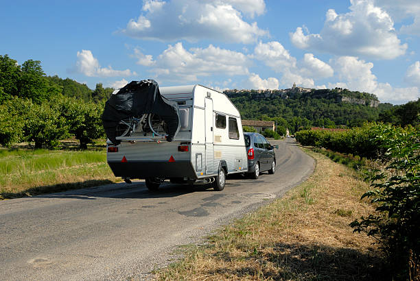 Car with caravan on a small road at the French countryside