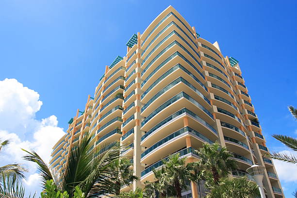 Looking up at a modern apartment building Tropical apartment building over looking the ocean tall person stock pictures, royalty-free photos & images