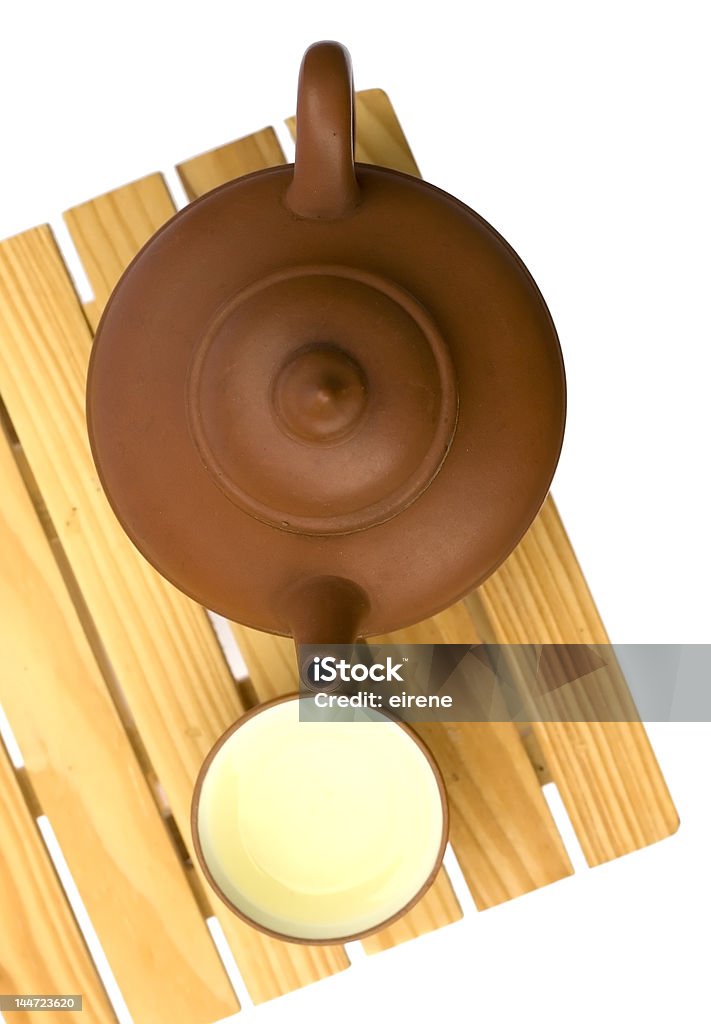 Tetera y teacup en una pequeña mesa de madera - Foto de stock de Alfarería libre de derechos