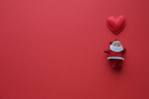 Santa Claus on a red background and a heart. Christmas concept. stock photo