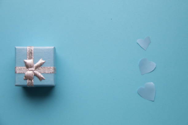 istock Blue hearts and gift on a blue background. Festive concept. 1447238924