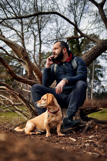 istock a handsome bearded man sitting in a park with his dog 1447240351