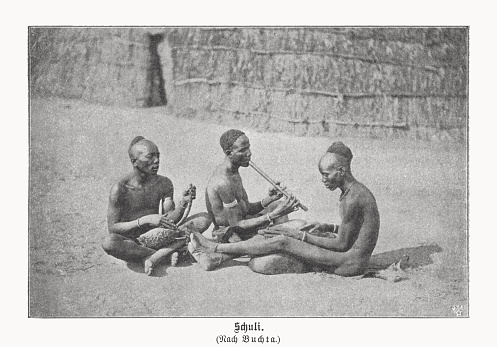 Acholi while making music. The Acholi (also Acoli) people are an ethnic group of just over one million people living east of the White Nile in northern Uganda in the Gulu, Kitgum and Pader districts and southern South Sudan. Halftone print after a photograph (ca. 1877/80) by Richard Buchta (Austrian Africa explorer, author and photographer, 1845 - 1894), published in 1899.