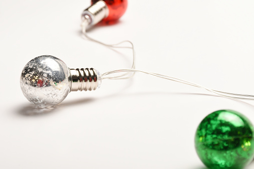 Christmas light bulbs on the white background with copy space. Colorful Christmas lights