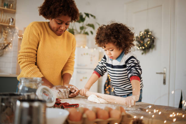 istock Mother making cookies in the kitchen with her cute toddler son 1447243748