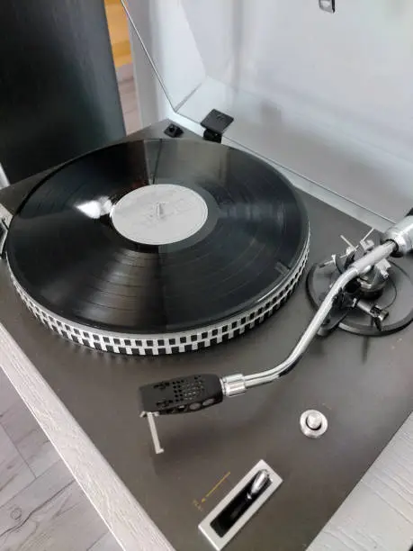 Photo of Rotary vinyl record player. Retro audio equipment for disc jockeys. DJ sound technology for mixing and playing music.