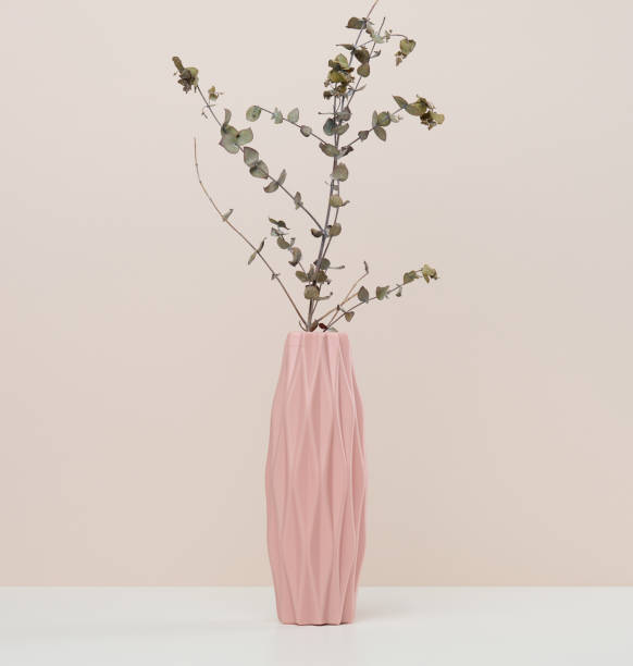 istock Pink ceramic vase with eucalyptus branch on white table 1447246557