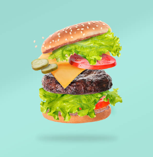 Flying big hamburger on turquoise background - fotografia de stock