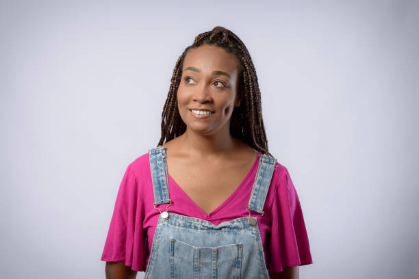 istock Young woman with afro hair with braid in studio on gray background 1447247994