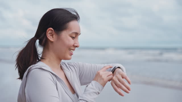 Asian sport woman using smart watch before exercise