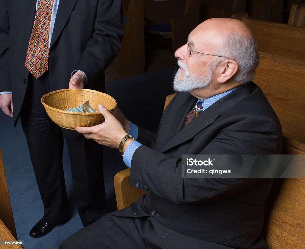 Senior Caucasian Man Handing Church Offering Basket to Usher Senior man handing a church offering basket to an usher  - See lightbox for more Church Stock Photo