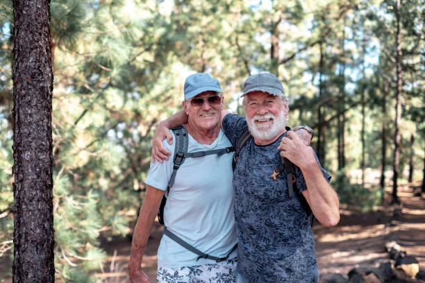 istock Happy smiling couple of elderly men with hat and backpack look in camera while enjoying mountain hike in the woods appreciating adventure and freedom, retired seniors and healthy lifestyle concept 1447250316