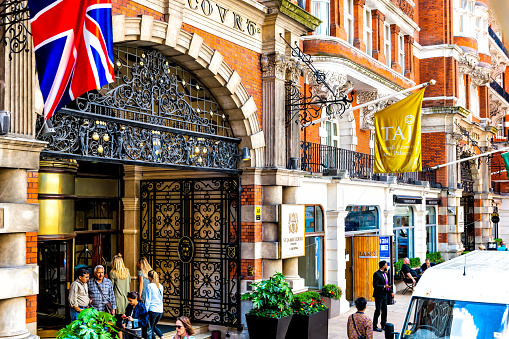 London, United Kingdom - June 22, 2018: St. James' Court Taj hotel resort entrance sign with Indian people tourists in city of Westminster