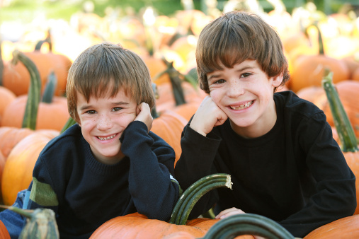 Boys Resting on a Pumpkin in the Pumpking Patch