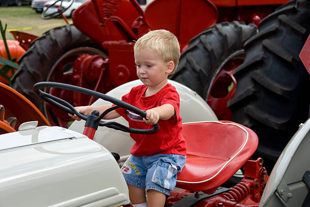 istock Small boy pretends to drive a tractor 144726131