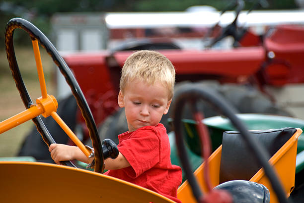 istock Young boy playing with a tractor steering wheel 144726146