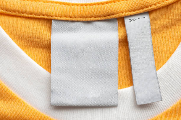istock Blank white laundry care clothes label on yellow fabric texture background 1447261636