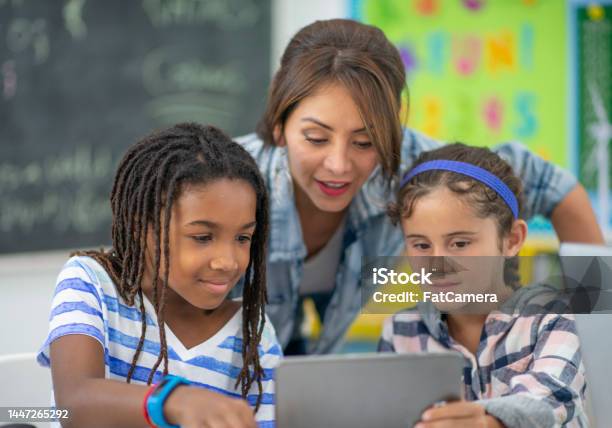 Teacher Assisting Students Stock Photo - Download Image Now - Teacher, Student, Classroom